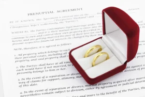A prenuptial agreement document alongside wedding rings, establishing financial clarity before marriage, is a practical step for couples in Singapore with assets to protect